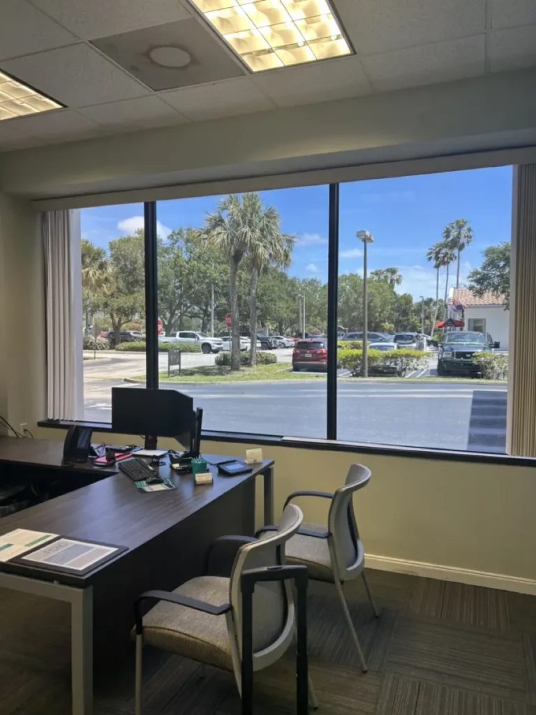 Office interior with tinted windows cutting glare at the desk
