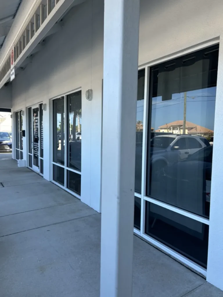 Tinted storefront windows along a retail plaza