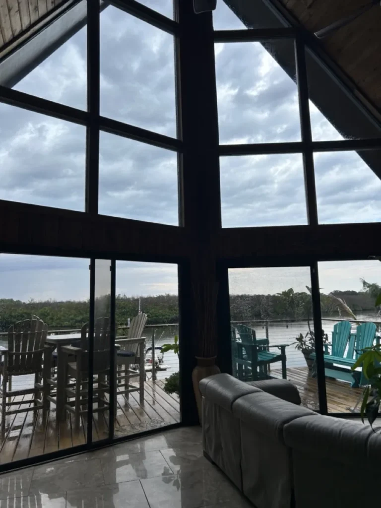 Tinted floor-to-ceiling windows in a waterfront home great room